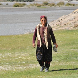 woman walking by Oxus river with Afghanistan in the background
